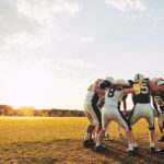 American football players in a huddle during practice